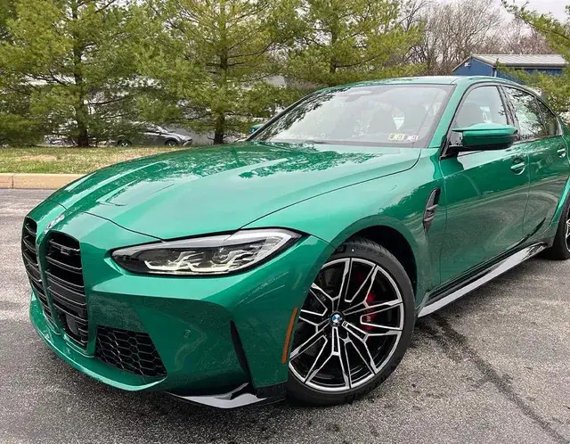 רכב BMW ירוק מבריק חונה ליד עצים