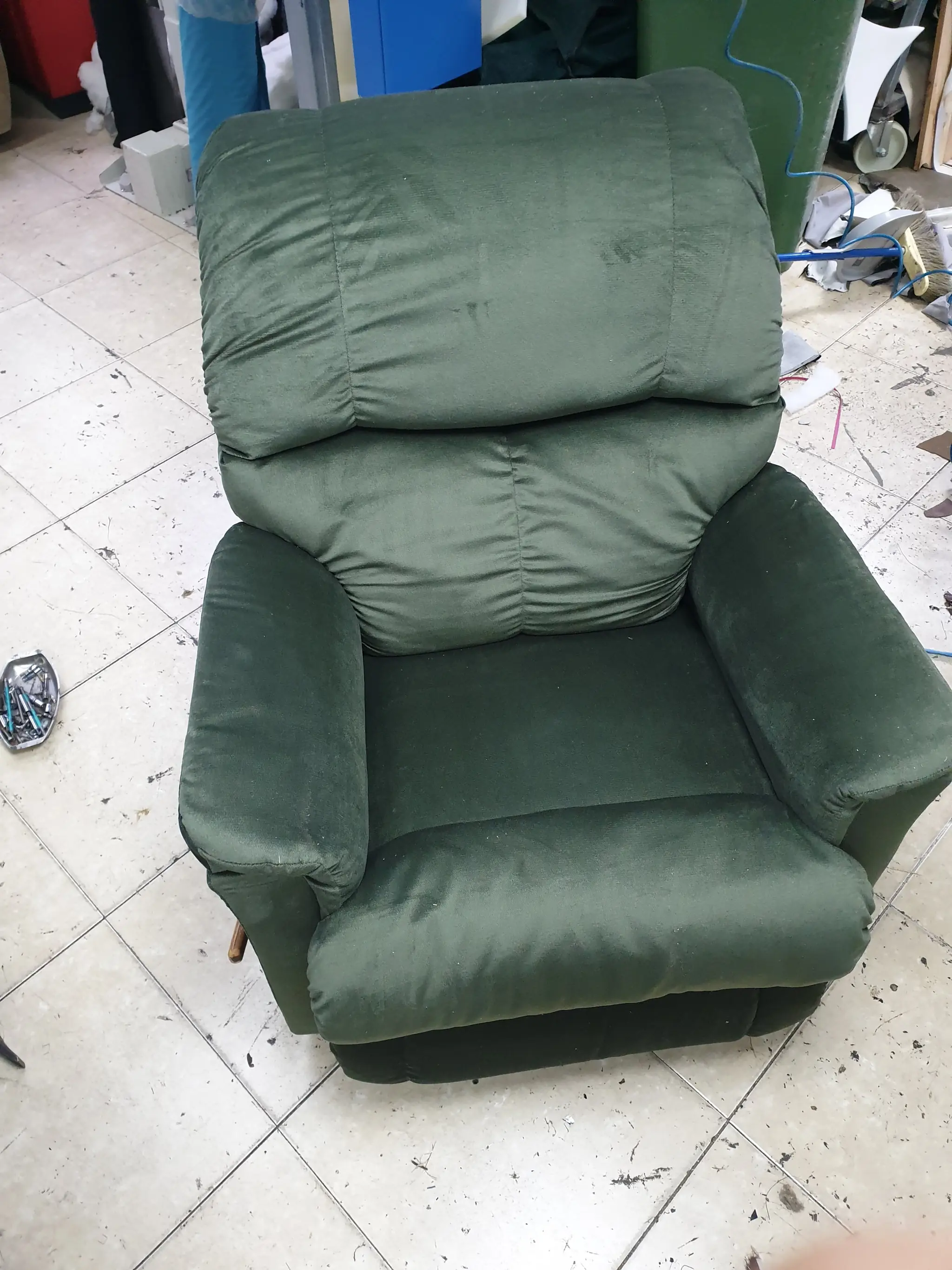 כורסה בצבע ירוק כהה עם ריפוד עבה ונעים למגע, המספק נוחות מקסימלית לישיבה