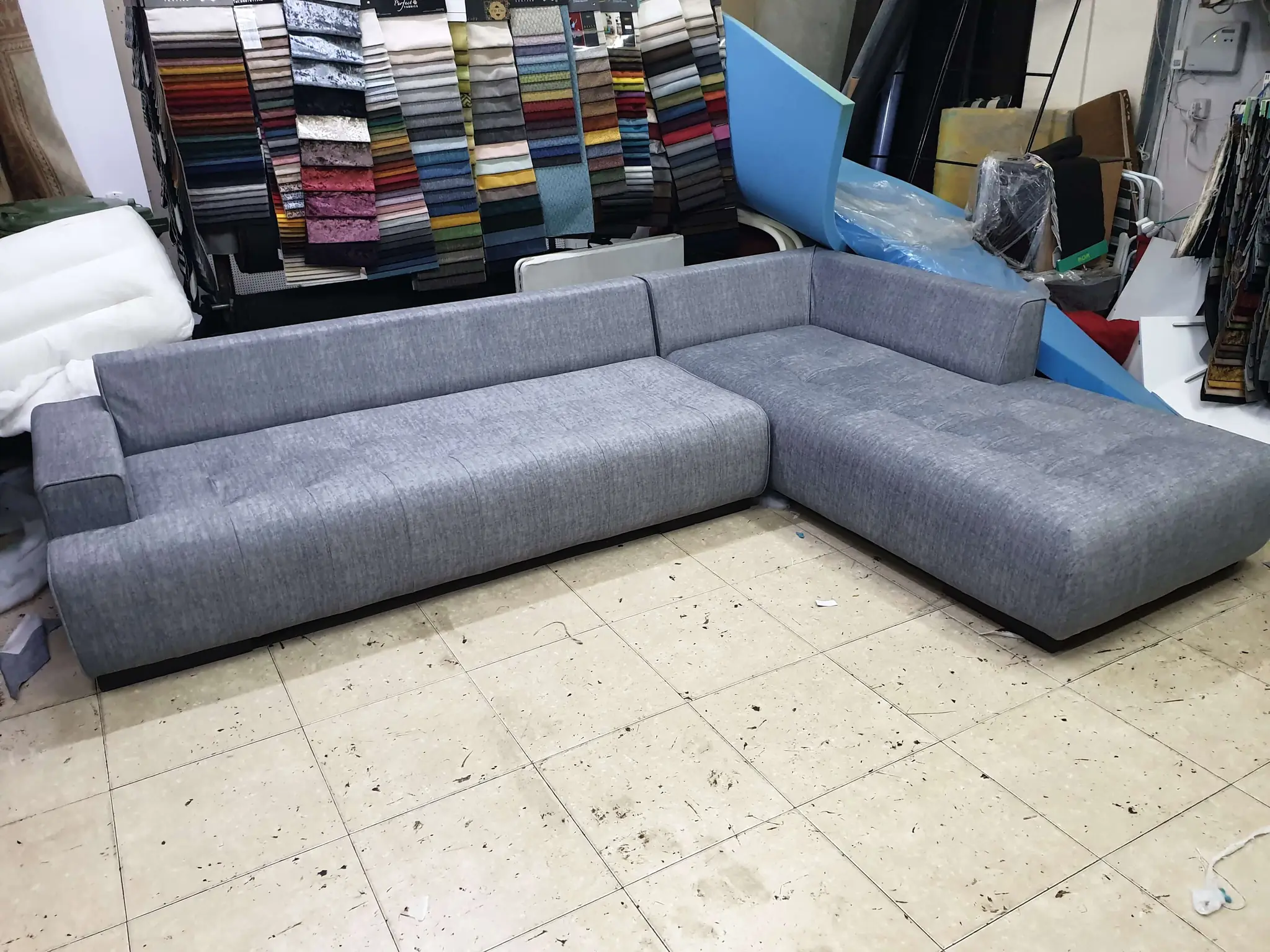 ספה פינתית מרווחת בצבע אפור בהיר, בעלת עיצוב מודרני ומינימליסטי. הספה עשויה מבד נעים למגע ומתאימה לפינת ישיבה בסלון רחב